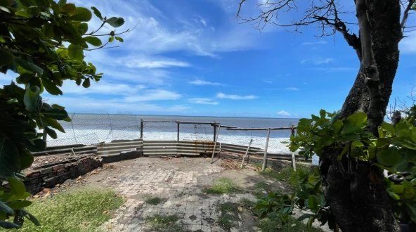 The Pacific beyond a low fence, at the far end of the land