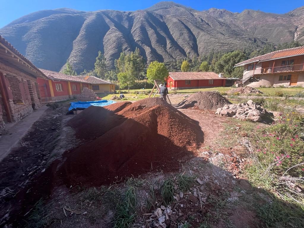 Movimiento de tierra junto a los edificios, con montañas detrás