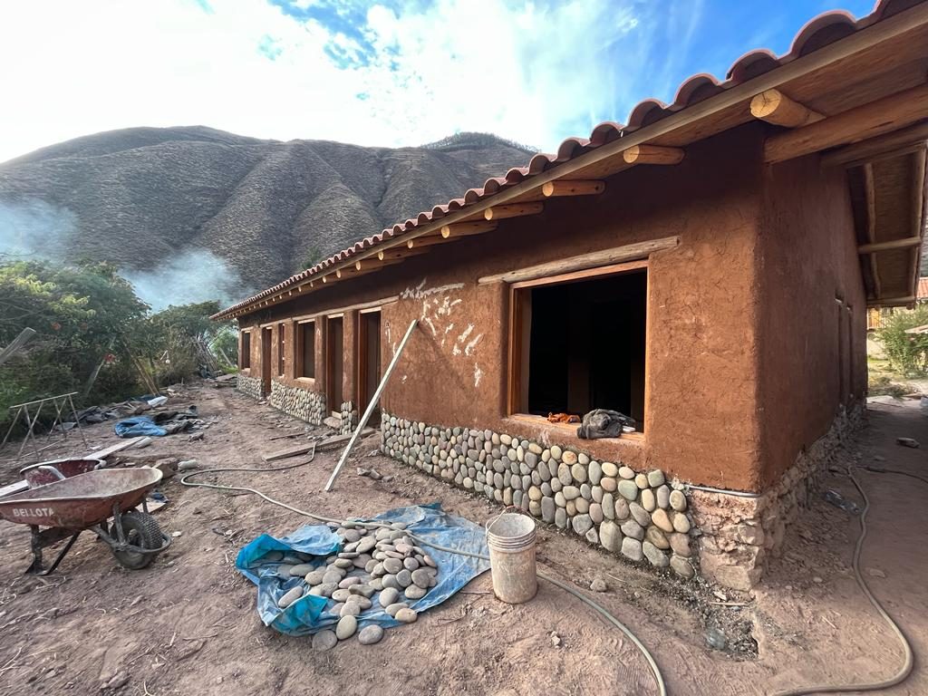 Base de piedra terminada a lo largo de un muro de tierra