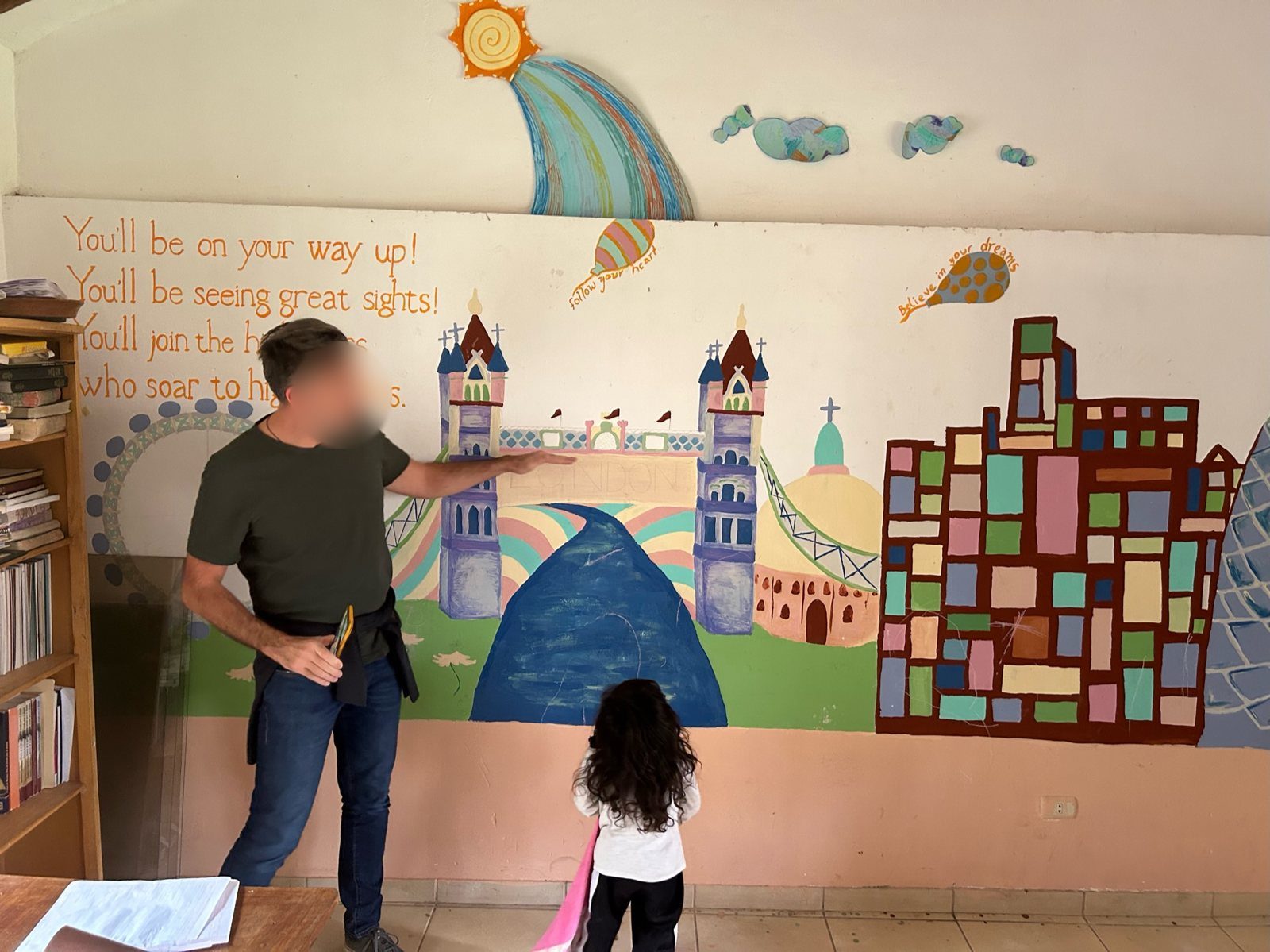 Un niño mirando un mural pintado de una ciudad