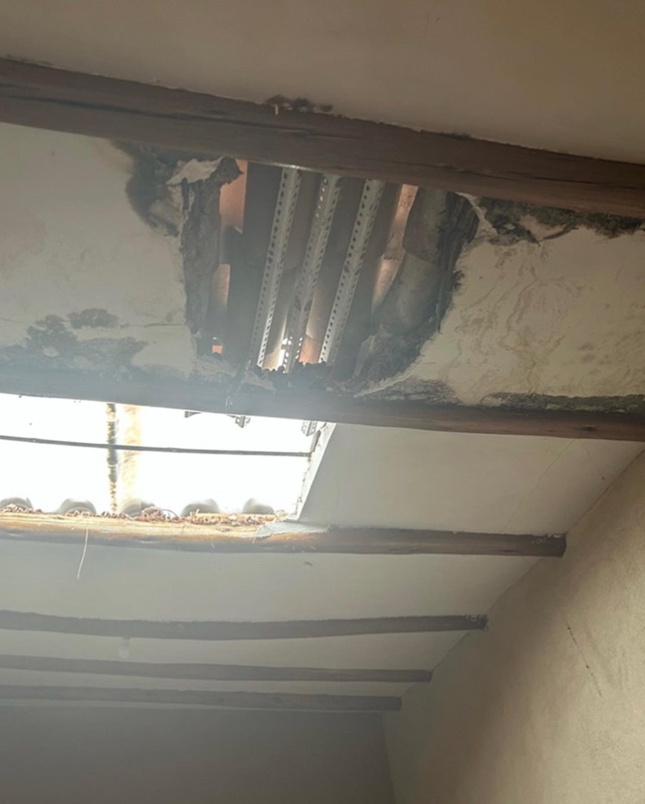 Un techo dañado por el que entra la luz del día
