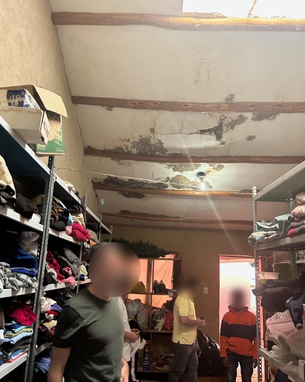 Un almacén con estantes de ropa donada