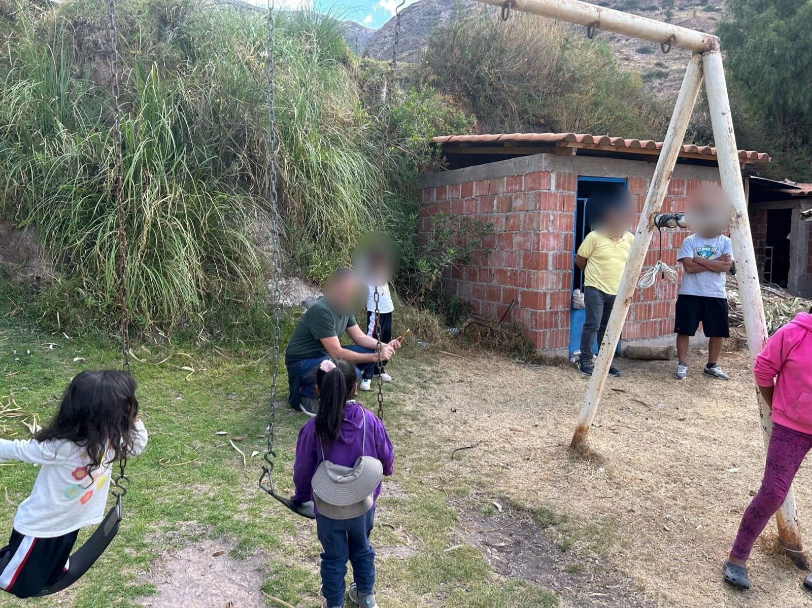 Niños jugando en columpios viejos de madera